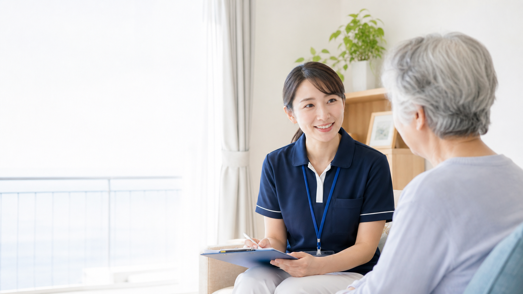 訪問看護師が利用者と明るい室内で話している様子